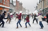 【画像素材】雪の降る街の通りで人々が雪合戦をする