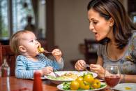 【画像素材】食卓で離乳食をあげている母親