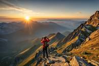 【画像素材】山頂から日の出を撮影する登山家